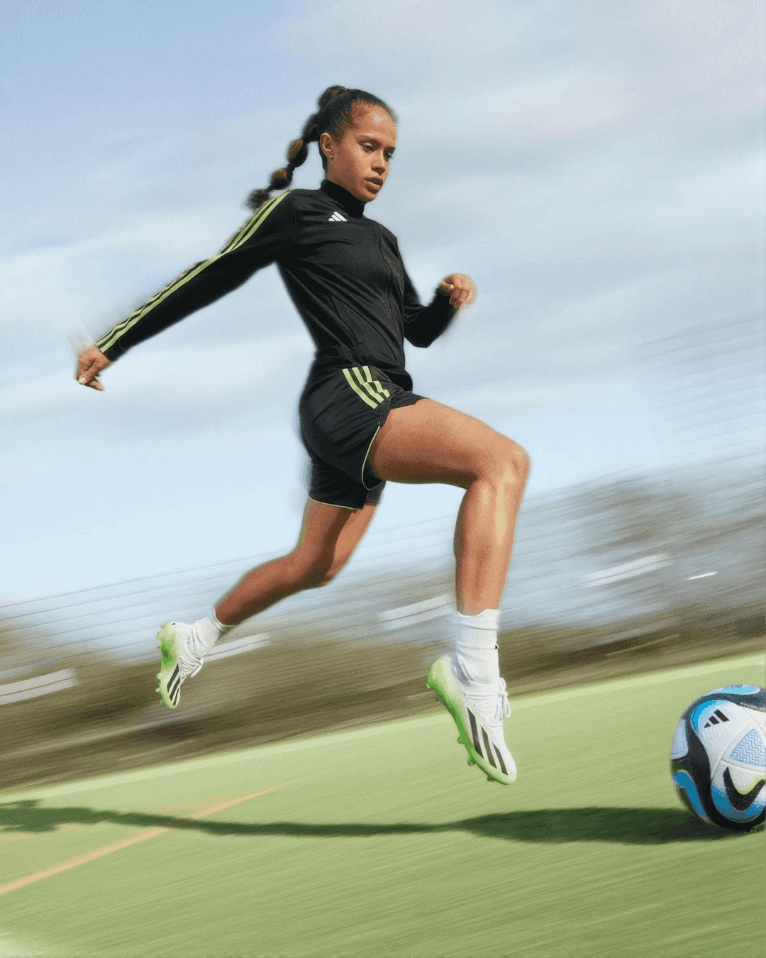 Footballer sprinting with the ball across a pitch